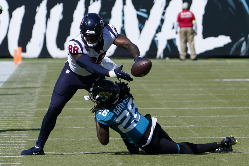 Houston Texans tight end Jordan Akins (88) catches a pass as Jacksonville Jaguars cornerback Shaquill Griffin (26) defends during the second half of an NFL football game in Jacksonville, Fla., Sunday, Oct. 9, 2022. (AP Photo/John Raoux)