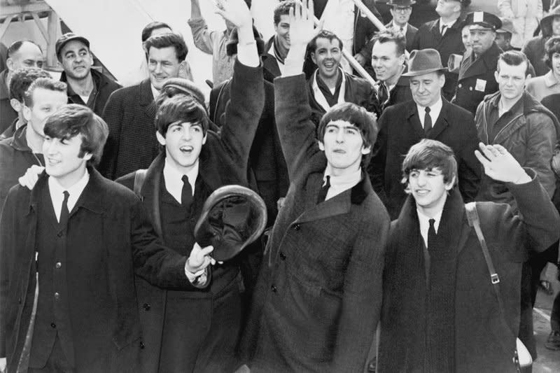 The Beatles wave to the thousands of screaming teenagers after their arrival at Kennedy Airport in New York City on February 7, 1964. On January 30, 1969, the Beatles staged an impromptu concert on the roof of Apple Records in London in the last public appearance by the band. File Photo by UPI