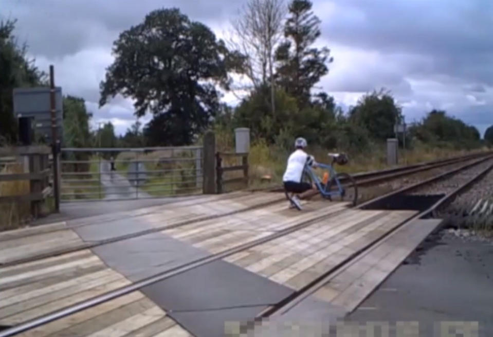 Shocking CCTV footage has been released which shows people risking their lives on level crossings - including a father and his young daughter posing for a photo shoot. The reckless father can be seen taking pictures of the little girl - who appears to be of primary school age - in different directions on the crossing. Their car can be seen in the background with its doors open as the youngster adopts various poses and occasionally looks behind her for approaching trains. Another shocking clip captured on CCTV shows a group of cyclists who dismount their bikes and line up for a group photo on the crossing.