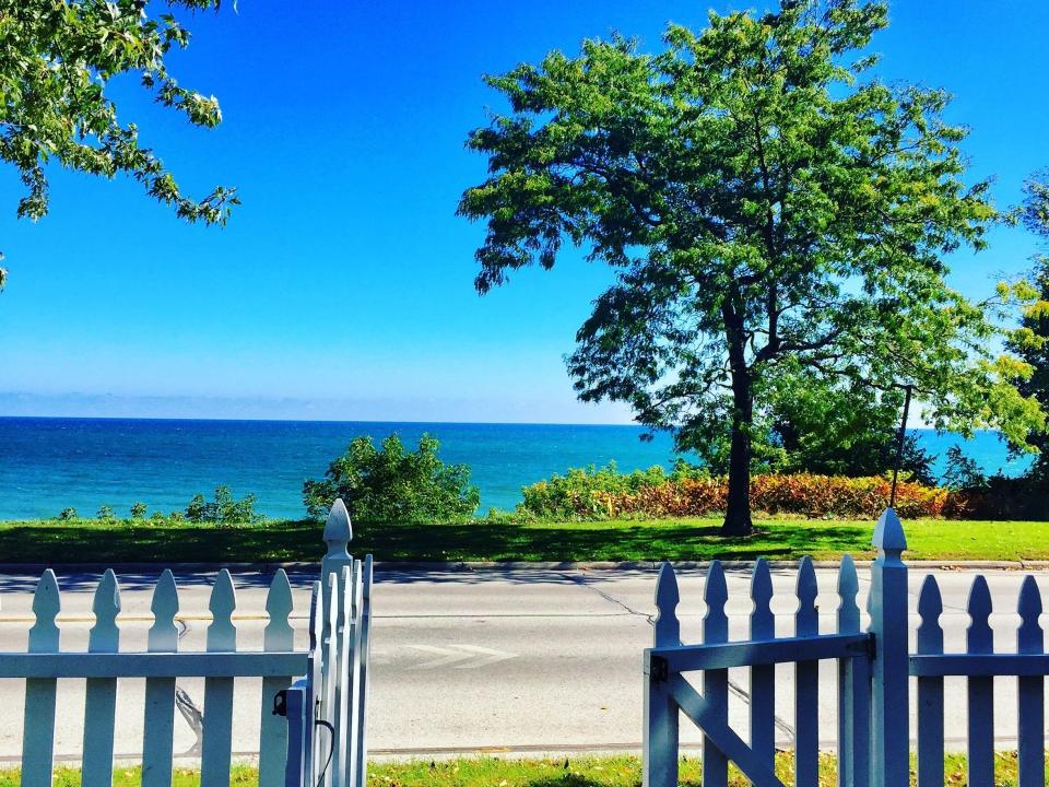 A view of a lake outside of a white picket fence in Wisconsin