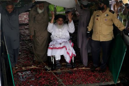 FILE PHOTO: Khadim Hussain Rizvi (on a wheelchair), leader of Tehrik-e-Labaik Pakistan islamist political party, gestures to his supporters during a campaign rally ahead of general election in Karachi, Pakistan July 1, 2018. REUTERS/Akhtar Soomro/File Photo