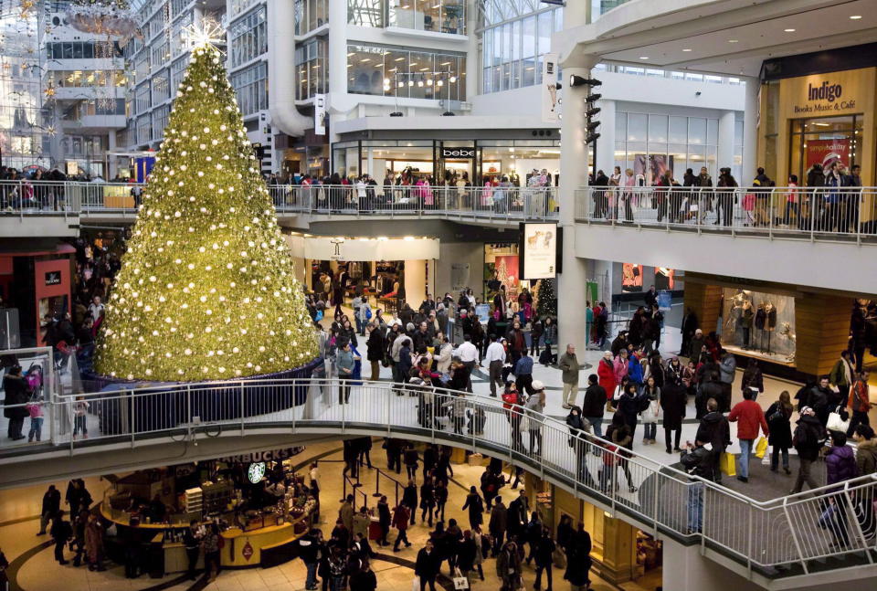 People Christmas shop in the Eaton Centre in Toronto, on December 23, 2009. Canadians will spend one to two per cent more this holiday season, but an increasing number will check for the best prices online before they head to the mall, a new study suggests. THE CANADIAN PRESS/Darren Calabrese