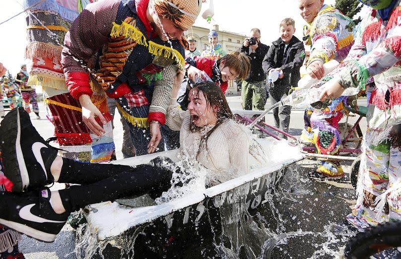 Une fille est aspergée d'eau par des garçons selon une tradition polonaise du lundi de Pâques, à Wilamowice, en Pologne, le lundi 17 avril 2017.