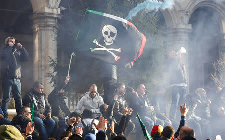 Taxi drivers shout slogans and burn flares during a rally in Rome, Italy, February 21, 2017. REUTERS/Alessandro Bianchi