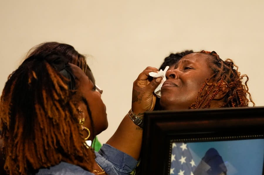 CORRECTS SERVICE BRANCH TO U.S. AIR FORCE INSTEAD OF U.S. NAVY – Family members wipe away the tears of Chantemekki Fortson, mother of Roger Fortson, a U.S. Air Force senior airman, as she holds a photo of her son during a news conference regarding his death, with attorney Ben Crump, Thursday, May 9, 2024, in Fort Walton Beach, Fla. Fortson was shot and killed by police in his apartment, May 3, 2024. (AP Photo/Gerald Herbert)