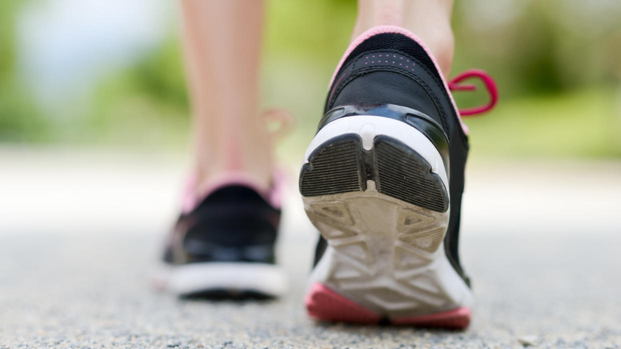  Woman walking wearing running shoes. 