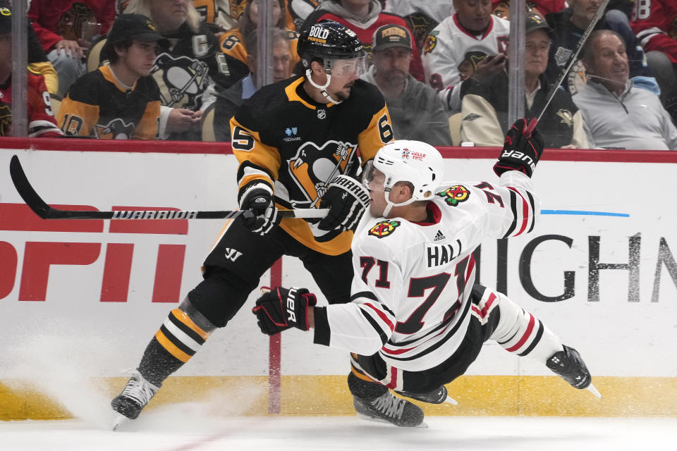 Pittsburgh Penguins' Erik Karlsson (65) collides with Chicago Blackhawks' Taylor Hall during the first period of an NHL hockey game in Pittsburgh, Tuesday, Oct. 10, 2023. (AP Photo/Gene J. Puskar)