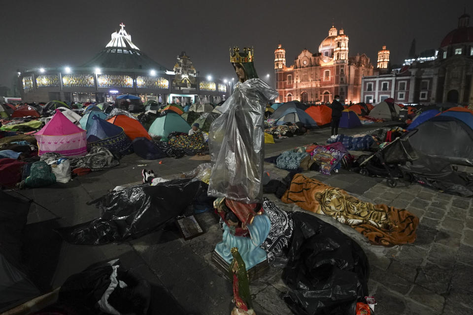 A statue of the Virgin of Guadalupe stands amid pilgrims sleeping outside the Basilica of Guadalupe on her feast day in Mexico City, early Tuesday, Dec. 12, 2023. Devotees of Our Lady of Guadalupe gather for one of the world's largest religious pilgrimages on the anniversary of one of several apparitions of the Virgin Mary witnessed by an Indigenous Mexican man named Juan Diego in 1531. (AP Photo/Marco Ugarte)