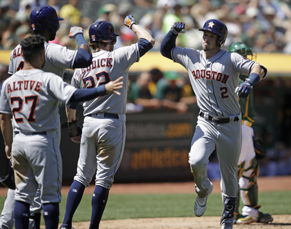 Houston Astros' Alex Bregman, right, is congratulated by Josh Reddick (22), Jose Altuve (27) and Yordan Alvarez after hitting a three run home run off Oakland Athletics' Brett Anderson in the fifth inning of a baseball game Sunday, Aug. 18, 2019, in Oakland, Calif. (AP Photo/Ben Margot)