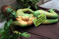 A People for the Ethical Treatment of Animals (PETA) activist poses with her body painted like snakeskin during a protest at the entrance to a shopping mall in Bangkok on December 8, 2010. The protest was organised to denounce the use of exotic animals' skins by luxury fashion brands - namely Hermes. AFP PHOTO/Christophe ARCHAMBAULT