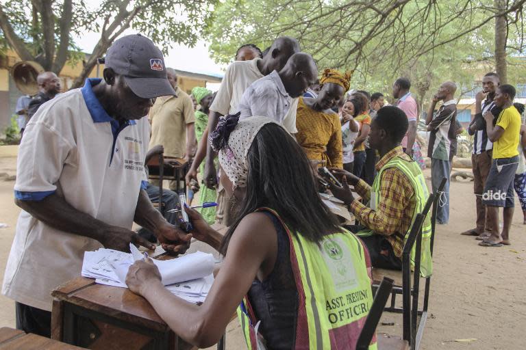 People wait in line to vote at a polling station in Lagos as Nigeria's general election went into a second day amid technical problems