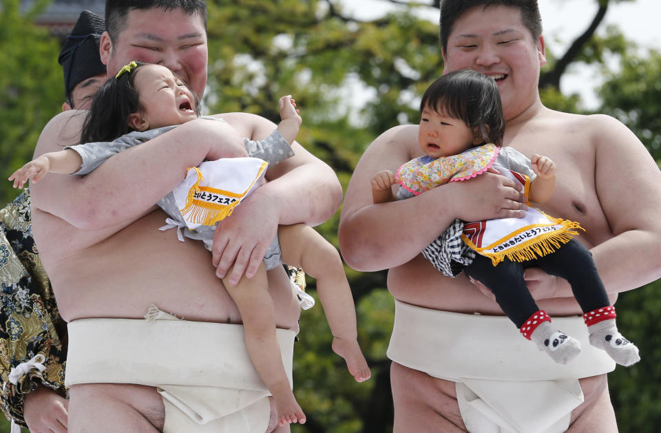 An unidentified baby, held by a college sumo wrester, cries during Naki Sumo, or Crying Baby Contest, as a judge looks on at Sensoji temple in Tokyo Monday, April 29, 2013. The babies born in 2012 participated in the annual traditional ritual performed as a prayer for their healthy growth.