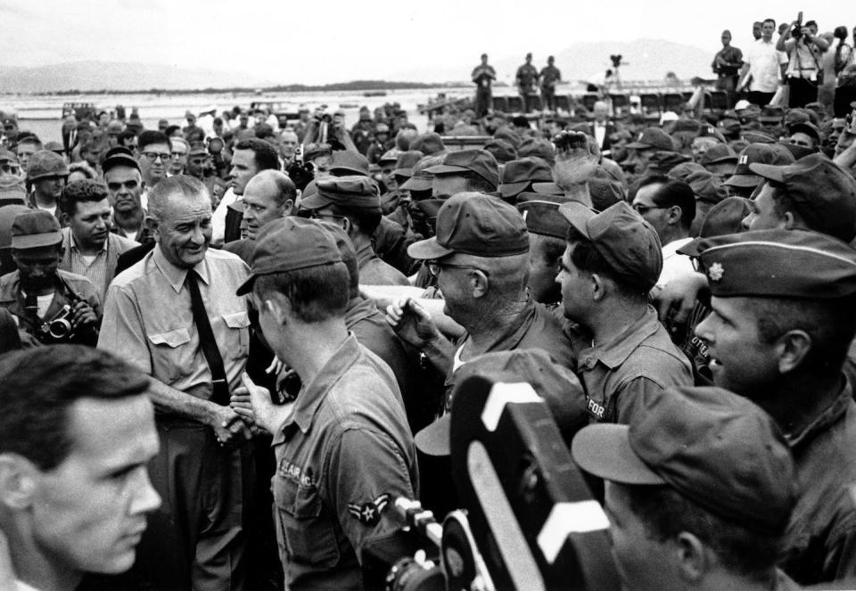 A crowd of American soldiers swarm around U.S. President Lyndon Johnson in October 1966 shortly after his arrival at Cam Rahn Bay in South Vietnam while visiting troops during the Vietnam War. (AP Photo)