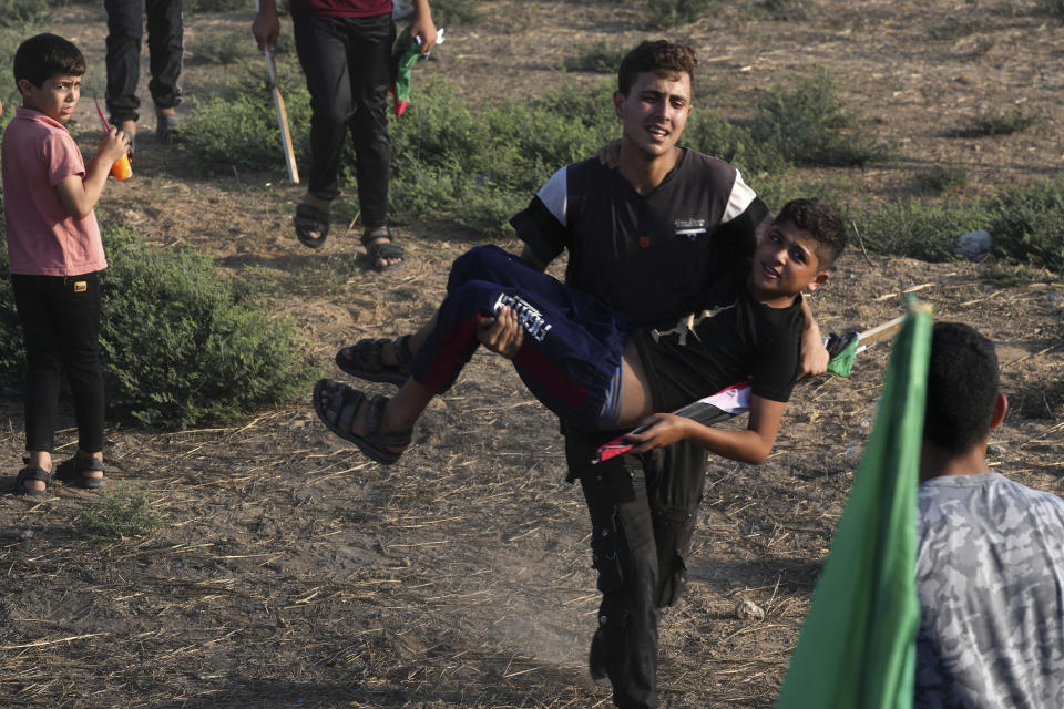 A Palestinian child is taken away after inhaling tear gas fired by Israeli soldiers during clashes along the frontier with Israel, east of Gaza City, Monday, Aug. 21, 2023. Hundreds of Palestinians protested near the border fence with Israel. (AP Photo/Adel Hana)