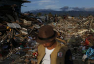 In this Oct. 5, 2018, photo, a man walks on the rubble of houses in the Petobo neighborhood which was wiped out by earthquake-triggered liquefaction in Palu, Central Sulawesi, Indonesia. Many in the decimated village had no idea they were in an area already identified as a high-risk zone for this apocalyptic phenomenon that causes soft ground to liquefy during temblors. The area around Sulawesi island's Palu Bay had been slammed before and was due for another potential perfect storm, capable of unleashing earthquakes, landslides, tsunami waves and soil liquefaction. (AP Photo/Dita Alangkara)