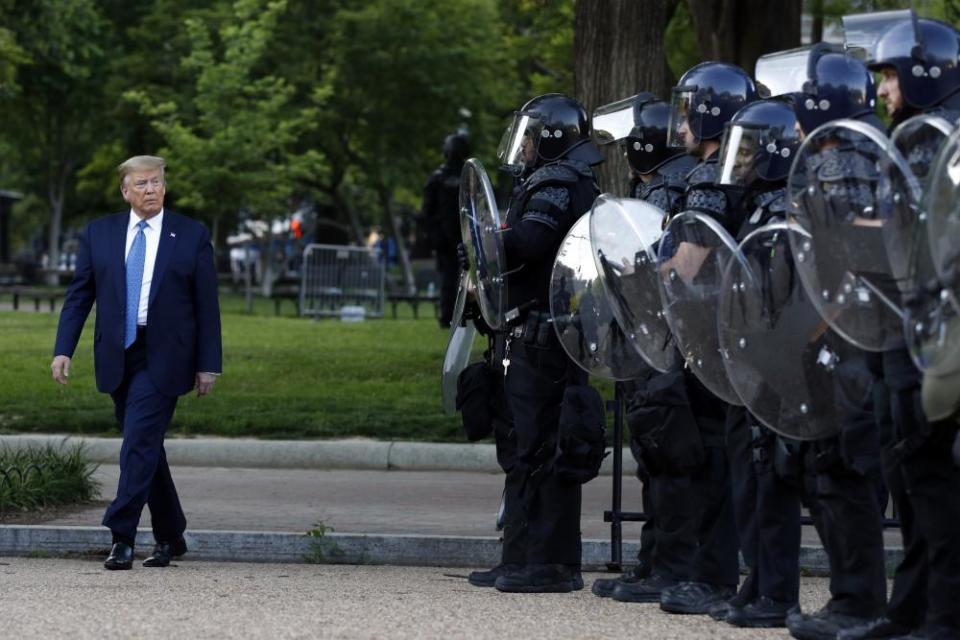 Donald Trump walks past police in Lafayette Park after the visit to St John’s Church across from the White House.