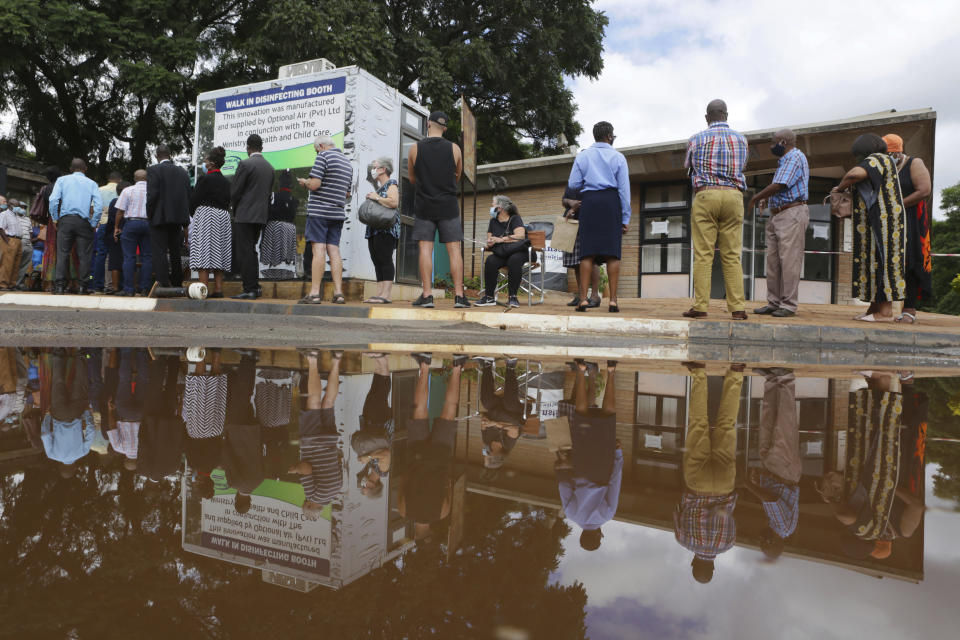 People wait in a queue to get a shot of the sinopharm coronavirus vaccination, at Wilkins Hospital in Harare, Wednesday, March, 24, 2021. Zimbabwe is rolling out its COVID-19 inoculation programme and in the first phase is targeting health care workers and the elderly. (AP Photo/Tsvangirayi Mukwazhi)