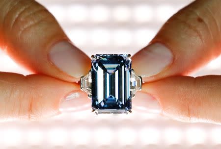 A Christie's employee poses with the 14.62 carats Oppenheimer Blue diamond during a preview in Geneva, Switzerland May 12, 2016. REUTERS/Denis Balibouse/File Photo