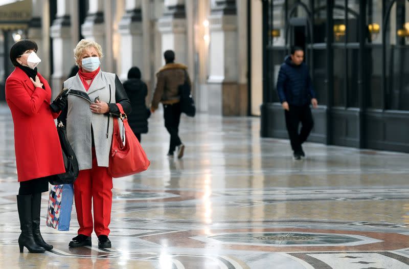 FILE PHOTO: Women in face masks are seen in Galleria Vittorio Emanuele II, after the Italian government imposed a virtual lockdown on the north of the country, in Milan