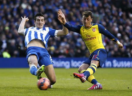 Arsenal's Mesut Ozil (R) scores a goal against Brighton and Hove Albion during their FA Cup fourth round soccer match at the Amex stadium in Brighton, southern England January 25, 2015. REUTERS/Stefan Wermuth