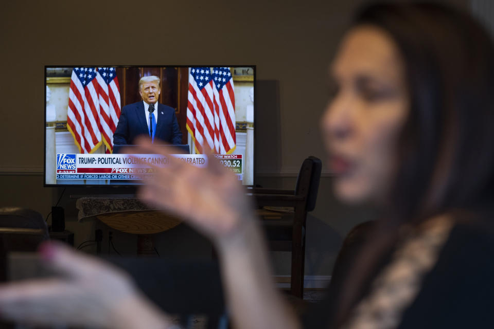 Natalie Abbas works at her "Command Post," her dining room table, as she watches Fox News broadcast President Donald Trump's farewell address, in Myersville, Md., Tuesday, Jan. 19, 2021, the day before the presidential inauguration. As a member of Braver Angels, Abbas, who believes the election was stolen, meets regularly with a neighbor who cheers Biden as the rightful winner, to ponder the greatest challenge facing Biden and American society: how can they find common ground if they no longer exist in the same reality? (AP Photo/Cliff Owen)