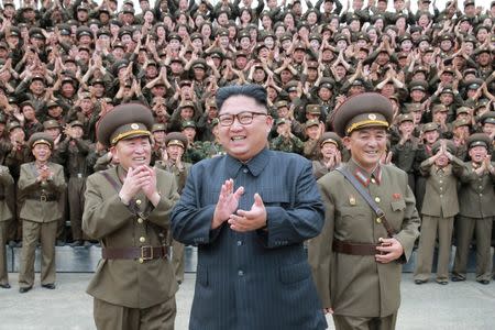 North Korean leader Kim Jong Un claps with military officers at the Command of the Strategic Force of the Korean People's Army (KPA) in an unknown location in North Korea in this undated photo released by North Korea's Korean Central News Agency (KCNA) on August 15, 2017. KCNA/via REUTERS