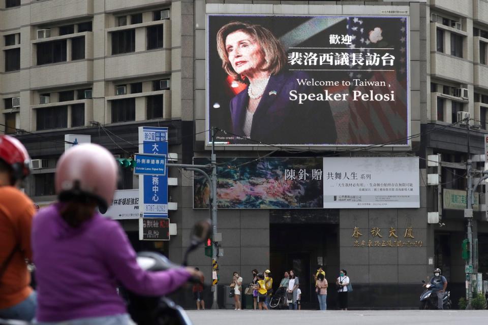 People walk past a billboard welcoming US House Speaker Nancy Pelosi, in Taipei, Taiwan on 3 August (AP)