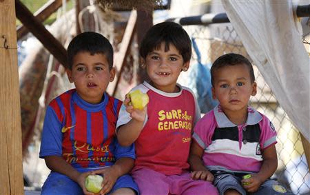 Syrian refugee children who arrived with their families from Damascus, eat fruits under a tent at the Majdal Anjar refugee camp in Bekaa Valley near the Syrian border in eastern Lebanon, September 9, 2013. REUTERS/Jamal Saidi