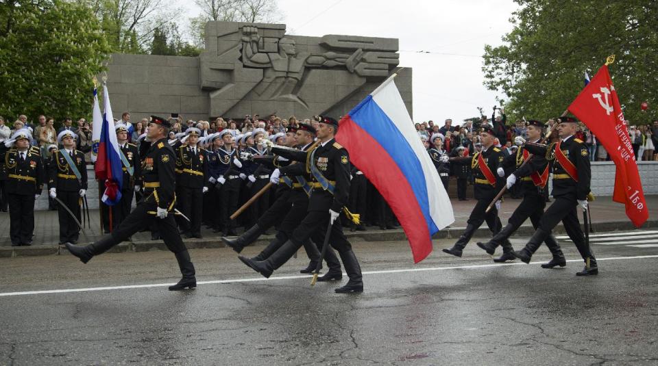 Russian marines carry national flags during a Victory Day military parade, which commemorates the 1945 defeat of Nazi Germany, in Sevastopol, Russia, on Friday, May 9, 2014. Russia marks the Victory Day on May 9 and Sevastopol marks 70th anniversary of liberation from German troops. (AP Photo/Ivan Sekretarev)