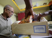 Officials of a Hindu temple open a box full of packaged food and sweets sent by a non-government organization to be distributed among villagers ahead of the inauguration of U.S. Vice President-elect Kamala Harris, in Thulasendrapuram, the hometown of Harris' maternal grandfather, south of Chennai, Tamil Nadu state, India, Tuesday, Jan. 19, 2021. The inauguration of President-elect Joe Biden and Vice President-elect Kamala Harris is scheduled be held Wednesday. (AP Photo/Aijaz Rahi)