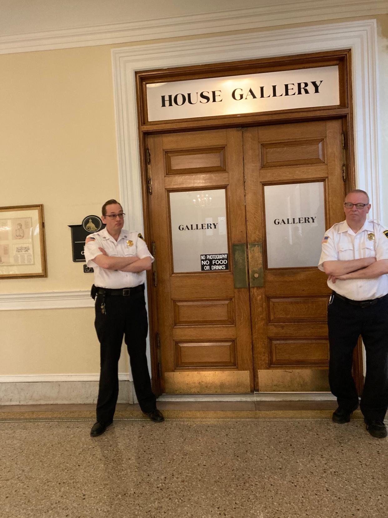 Two of the Statehouse court officers stand by the door to the House chambers gallery as climate activists disrupted the informal session Wednesday, demanding the Legislature address fossil fuel infrastructure.