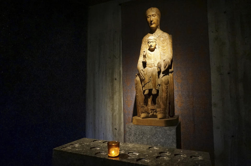 A 12th-century French statue of the Virgin Mary and the child Jesus reflects candlelight in a small chapel inside the campus church of Saint John's University in Collegeville, Minn., on Tuesday, Nov. 8, 2022. The university, founded by Benedictine monks whose monastery stands next to the church, and its twin institution for women, the College of Saint Benedict, have made efforts to welcome and affirm LGBTQ students, a fraught concern for faith-based schools across the country. (AP Photo/Giovanna Dell'Orto)