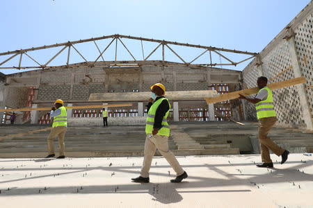 Construction workers carry wooden beams as they take part in the renovation project of Somalia's National Theatre in Mogadishu, Somalia February 3, 2019. Picture taken February 3, 2019. REUTERS/Feisal Omar
