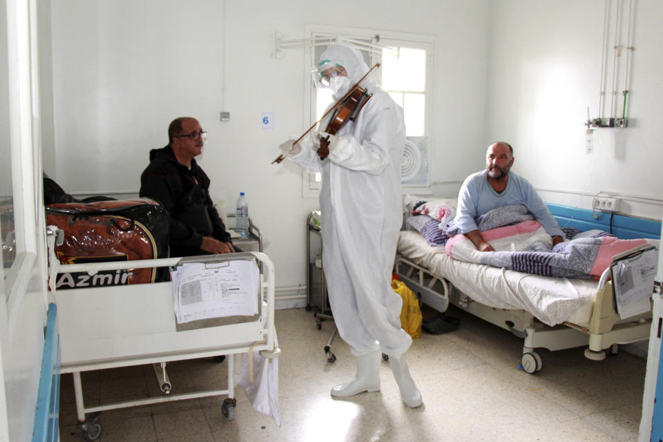 Dr. Mohamed Salah Siala plays the violin for patients on the COVID wards of the Hedi Chaker hospital in Sfax, eastern Tunisia, Saturday Feb. 20, 2021. When the 25-year-old decided to get out his violin one day at Hedi Chaker Hospital in city of Sfax and play, it won praise for boosting the morale of virus sufferers who remained isolated and needed a smile. (AP Photo)