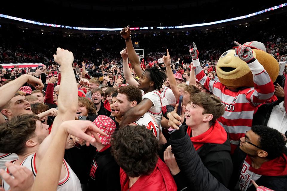 Ohio State players celebrate as fans storm the court following Sunday's win over Purdue.