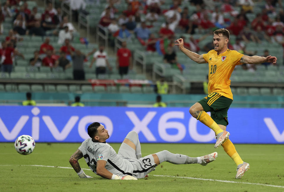 Wales' Aaron Ramsey, right, scores his sides first goal past Turkey's goalkeeper Ugurcan Cakir during the Euro 2020 soccer championship group A match between Turkey and Wales the Baku Olympic Stadium in Baku, Azerbaijan, Wednesday, June 16, 2021. (Naomi Baker/Pool via AP)