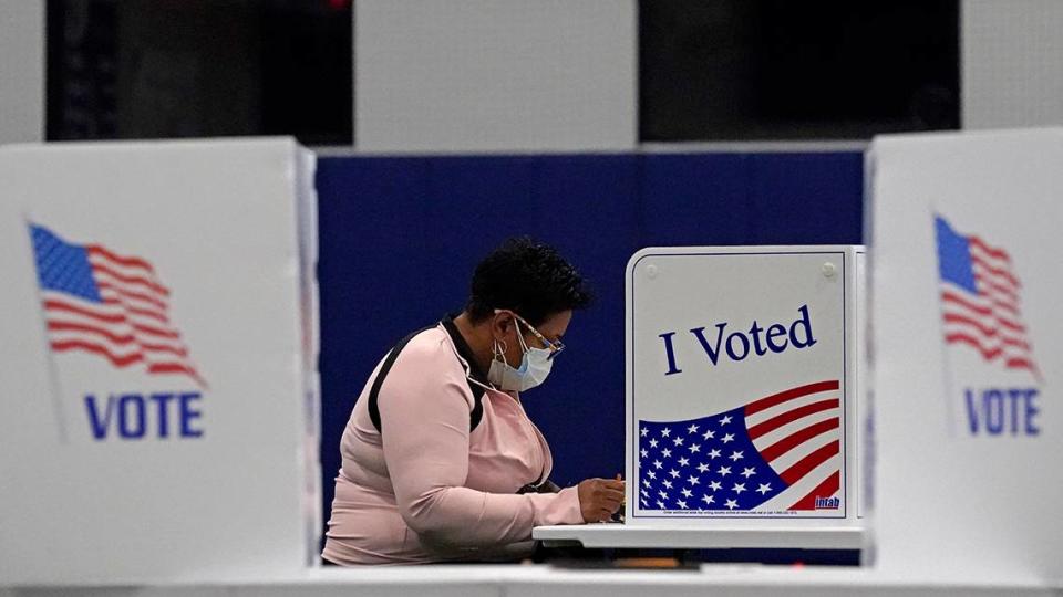 In this Nov. 3, 2020, file photo, a woman votes at the MLB Urban Youth Academy in Kansas City, Missouri.