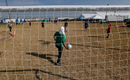 Immigrants play soccer at the U.S. government's newest holding center for migrant children in Carrizo Springs