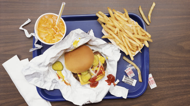 burger drink and fries on blue tray overhead