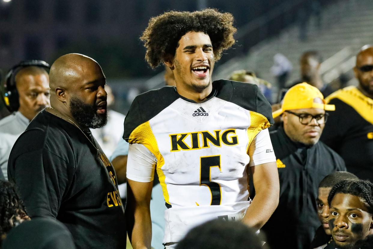 Detroit King quarterback Dante Moore (5) talks to teammates after 28-23 win over Detroit Cass Tech at Cass Technical High School in Detroit on Friday, Sept. 16, 2022.