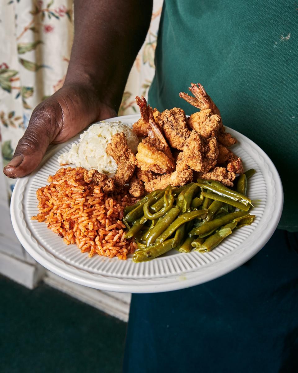 Owner Bill Green serves up a few of his specialties: fried shrimp, fried shark, green beans, red rice and potato salad.