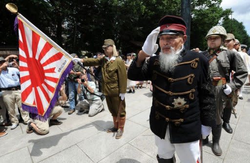 A war veteran (2nd R) leads others clad in costumes of the Imperial Japanese Army during a visit to Yasukuni Shrine to pray for war victims in Tokyo on August 15, 2012