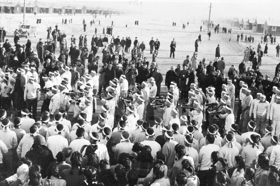 This photo made available by the National Archives and Records Administration shows Bugle Corps of Hokoku Seinen Dan gather at Gate 1 to give proper send off to 125 of their number being sent to Santa Fe Internment Camp at Tule Lake concentration camp, California, March 4, 1945. Government records show that Hidekazu Tamura, a former Japanese-American living in California, was at Tule Lake starting Oct. 8, 1943, and was sent to Santa Fe Internment Camp on Dec. 27, 1944. Records provided by the Tule Lake Committee show Tamura was a member of the Hokoku Seinen Dan’s leadership.(Courtesy of the National Archives and Records Administration via AP)