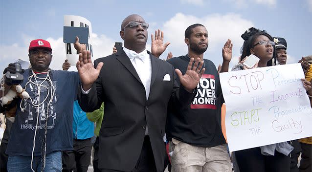 A group of protesters marches along a closed street, rallying in front of the town's police headquarters to protest the shooting of 18-year-old Michael Brown by Ferguson police officers. Photo: AP.
