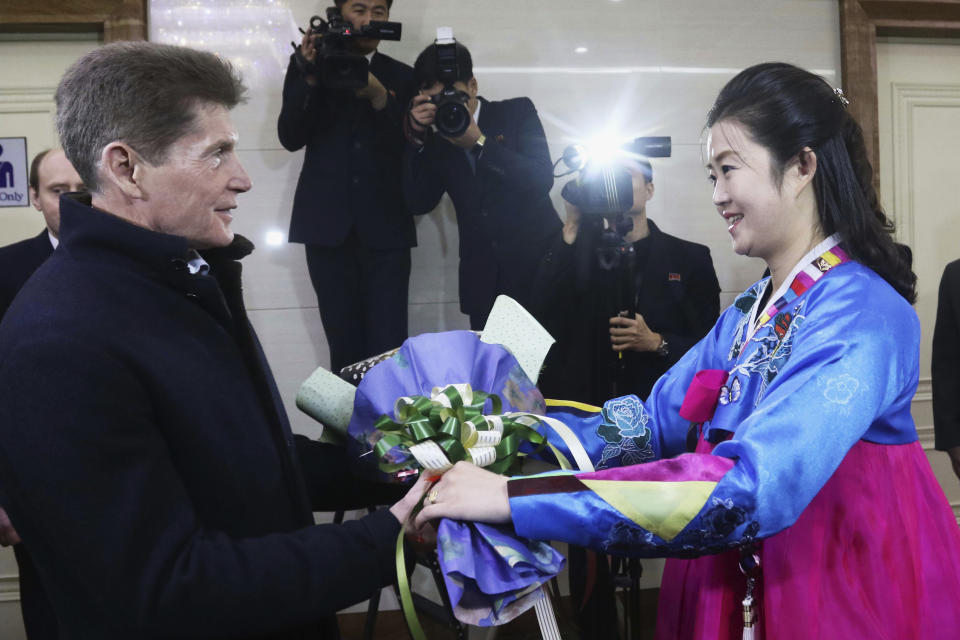 Oleg Kozhemyako, Russia's governor of the Maritime Territory Administration, receives a bouquet of flowers from a North Korean woman after he arrived at the Pyongyang International airport in Pyongyang, North Korea, Monday, Dec. 11, 2023. (AP Photo/Jon Chol Jin)