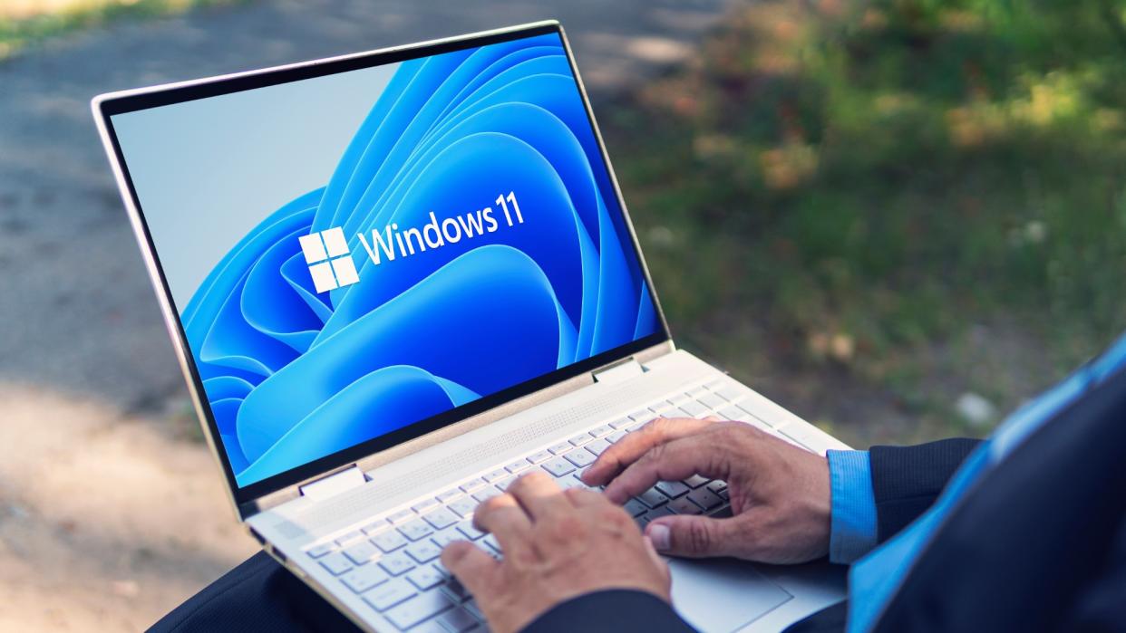  Man typing on Windows 11 laptop . 