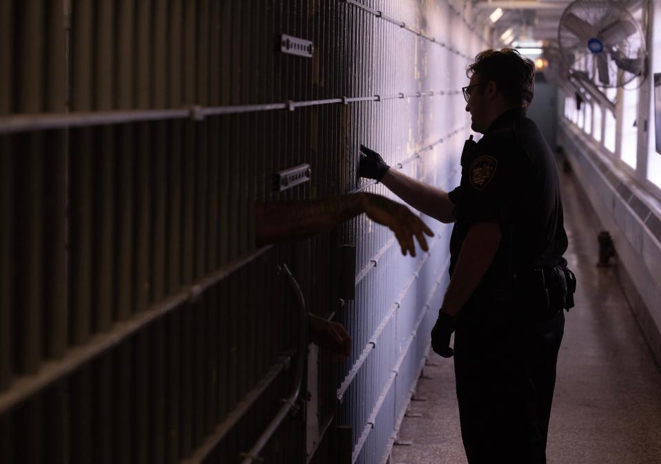 Stark County corrections officer Lucas Kazar checks on inmates at the Stark County Jail.