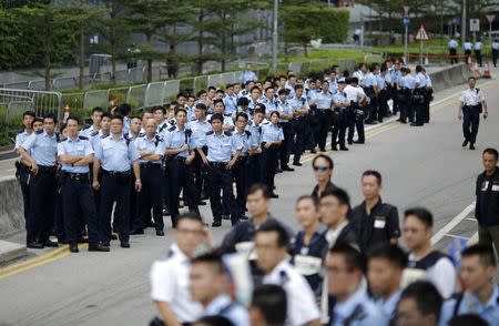 Police officers gather as protesters block the entrance to Hong Kong's Chief Executive Leung Chun-ying offices in Hong Kong, October 2, 2014. REUTERS/Carlos Barria