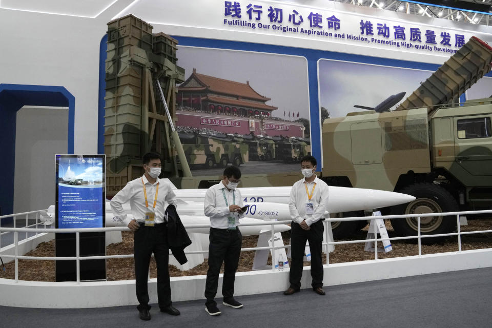 Workers wearing masks stand near missiles produced by China Aerospace Science and Industry Corp.displayed during the 13th China International Aviation and Aerospace Exhibition, also known as Airshow China 2021 on Tuesday, Sept. 28, 2021 in Zhuhai in southern China's Guangdong province. China on Friday, Jan. 21, 2022 criticized Washington for imposing sanctions on Chinese companies the U.S. says exported missile technology and accused the United States of hypocrisy for selling nuclear-capable cruise missiles. (AP Photo/Ng Han Guan)