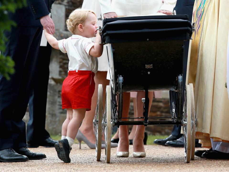 Prince George peeks into Princess Charlotte's stroller at her christening